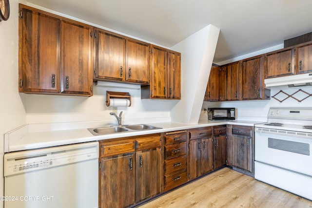 kitchen with light hardwood / wood-style flooring, white appliances, and sink