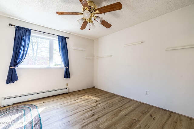 empty room featuring hardwood / wood-style floors, ceiling fan, baseboard heating, and a textured ceiling