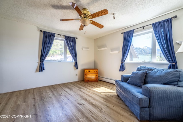 unfurnished room featuring hardwood / wood-style flooring, a baseboard heating unit, ceiling fan, and a textured ceiling