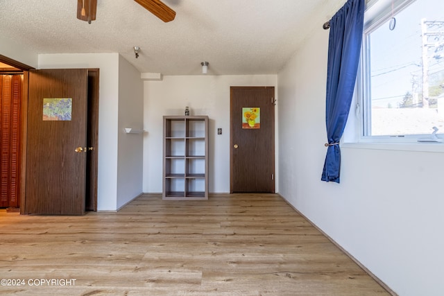 interior space with hardwood / wood-style flooring, ceiling fan, and a textured ceiling