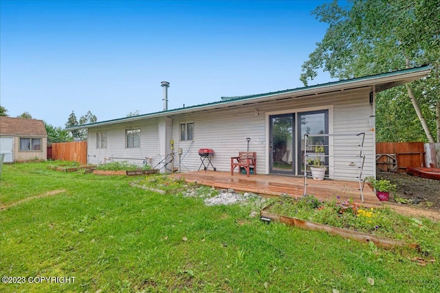 back of property featuring a deck and a lawn