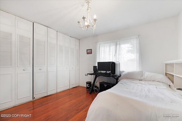 bedroom featuring an inviting chandelier, a closet, and hardwood / wood-style floors