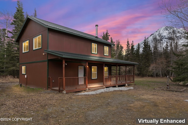 back house at dusk with covered porch