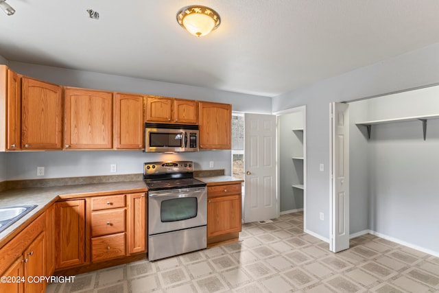 kitchen featuring sink, stainless steel appliances, and light tile floors