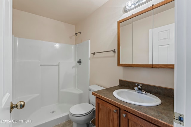 bathroom featuring walk in shower, tile floors, vanity with extensive cabinet space, and toilet