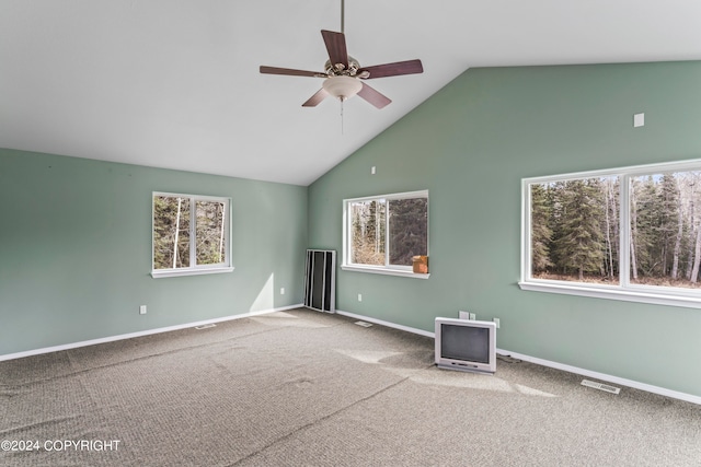 carpeted spare room featuring plenty of natural light, high vaulted ceiling, and ceiling fan