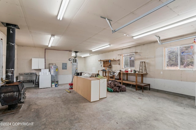 garage featuring strapped water heater, washer / dryer, and a workshop area