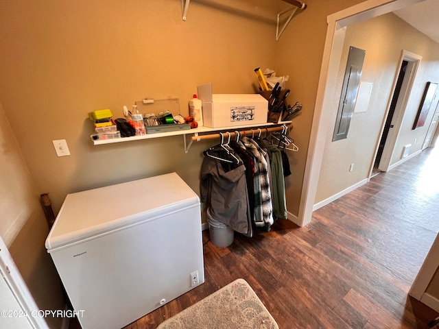 clothes washing area featuring dark wood-style floors, electric panel, and baseboards