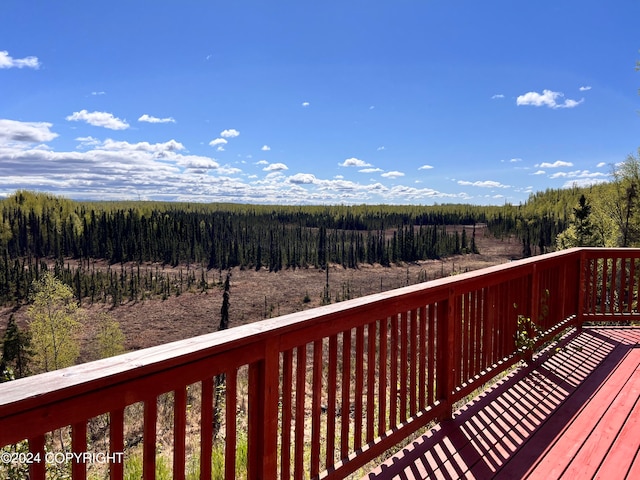 wooden terrace featuring a forest view