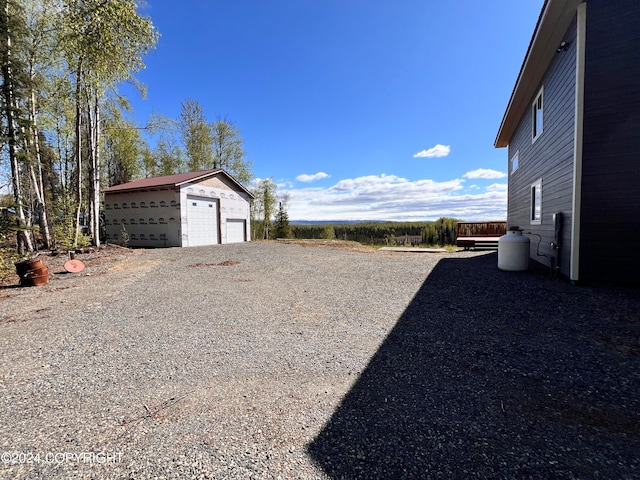 view of yard with a detached garage and an outdoor structure