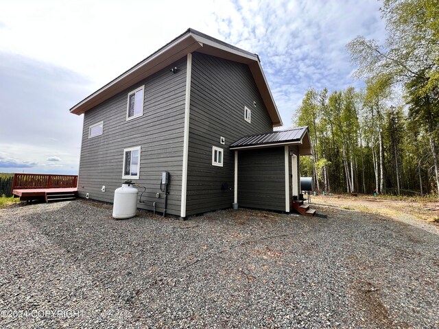 view of property exterior featuring metal roof and a wooden deck