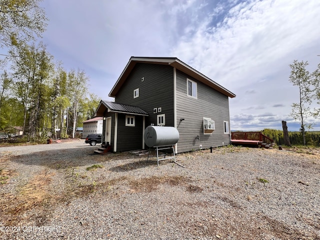 rear view of house with metal roof, a deck, and heating fuel