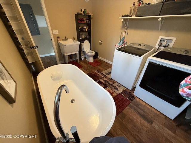 interior space with laundry area, separate washer and dryer, a sink, and wood finished floors