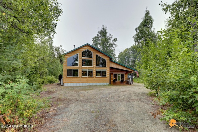 chalet / cabin with covered porch and dirt driveway