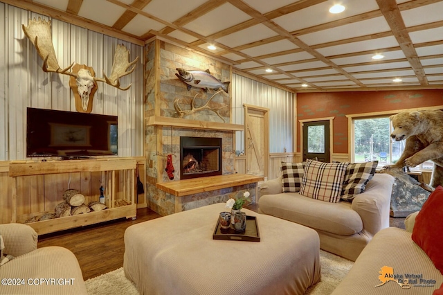 living room with a stone fireplace, light hardwood / wood-style flooring, beamed ceiling, and coffered ceiling