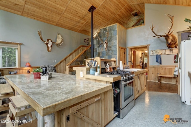 kitchen featuring sink, wooden ceiling, high vaulted ceiling, white refrigerator, and stainless steel range with gas stovetop