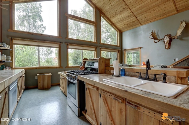 kitchen featuring high vaulted ceiling, stainless steel gas range oven, wooden ceiling, and a sink