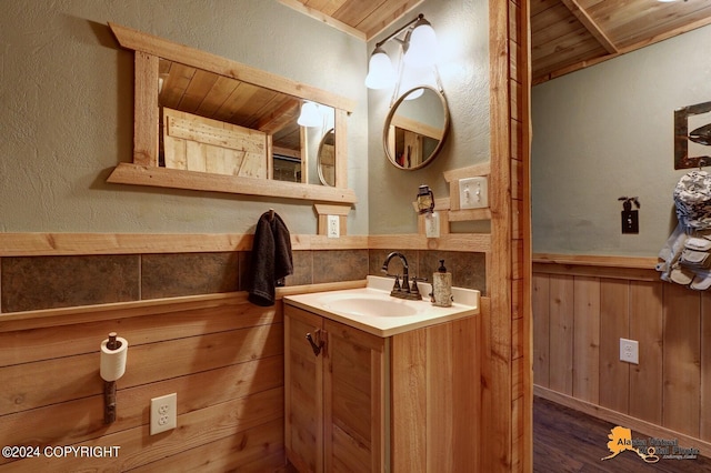 bathroom with wooden walls, wainscoting, wooden ceiling, wood finished floors, and vanity