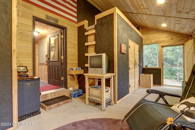 interior space with lofted ceiling, wood walls, and wood ceiling