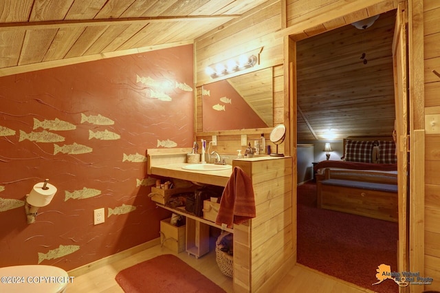 half bathroom featuring a textured wall, toilet, vaulted ceiling, vanity, and wooden ceiling