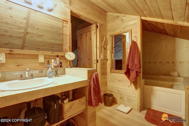 full bath with lofted ceiling, wood walls, vanity, wood ceiling, and a tub