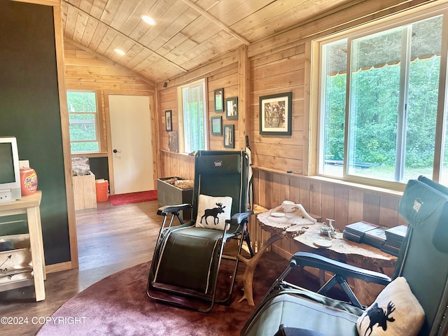 living area with lofted ceiling, wood ceiling, wood walls, and wood finished floors