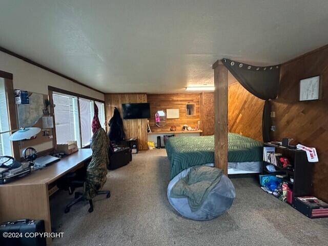 home office featuring carpet flooring and wood walls