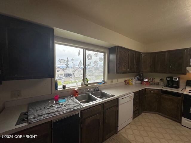 kitchen with dark brown cabinetry, dishwasher, sink, and range with electric stovetop