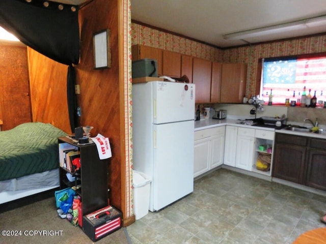 kitchen with white cabinetry, sink, and white refrigerator