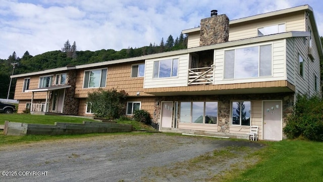 106 E Bayview Ave, Homer, AK 99603 - view of front of home with a chimney, stone siding, and a balcony