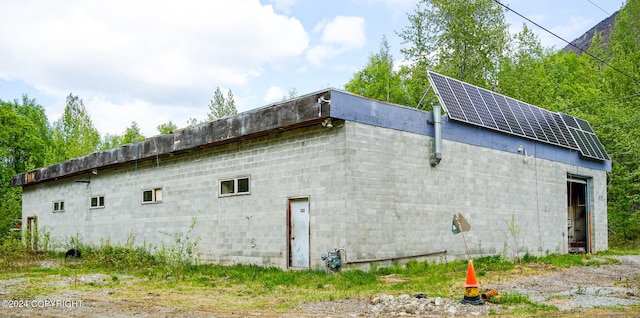 view of side of property featuring solar panels