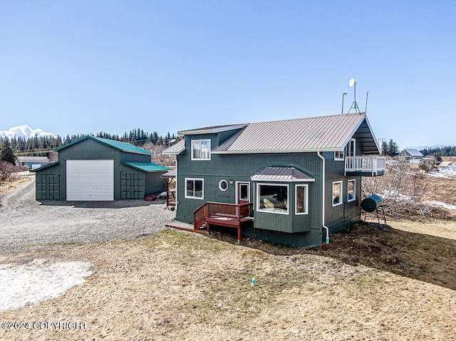 view of front of house with a deck, a garage, and an outdoor structure