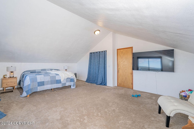 carpeted bedroom with a textured ceiling and vaulted ceiling