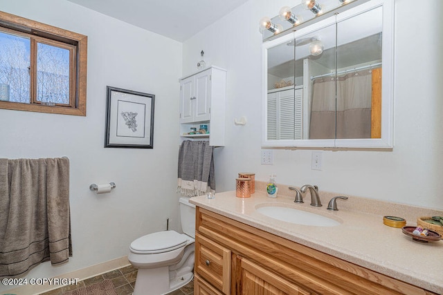 bathroom with tile floors, vanity, and toilet