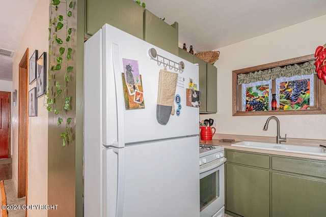 kitchen featuring sink, green cabinets, white appliances, and wood-type flooring