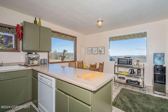 kitchen featuring green cabinetry, light tile flooring, white dishwasher, and kitchen peninsula