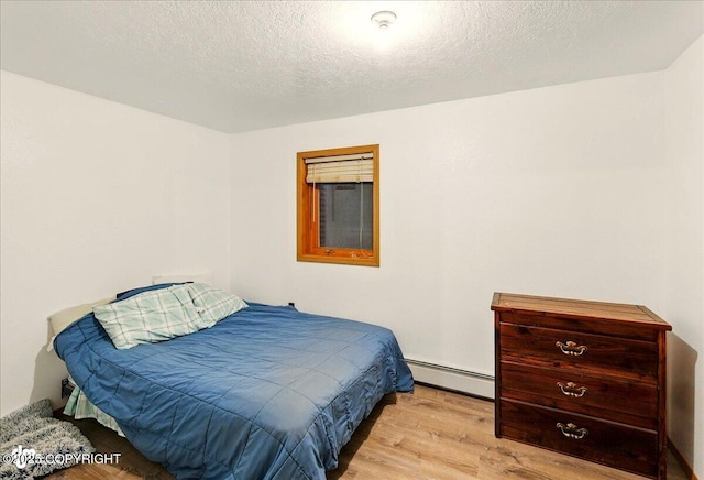44775 Carver Dr, Kenai, AK 99611 - bedroom with a baseboard heating unit and light wood-style flooring