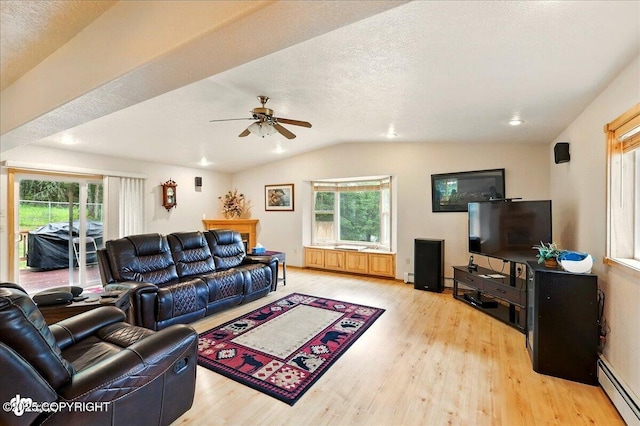 44775 Carver Dr, Kenai, AK 99611 - living room with baseboard heating, light wood-style floors, vaulted ceiling, ceiling fan, and plenty of natural light