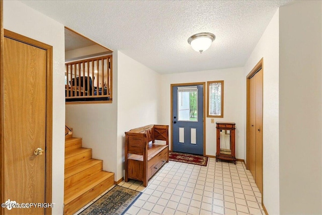 44775 Carver Dr, Kenai, AK 99611 - foyer entrance with a textured ceiling, baseboards, and stairway