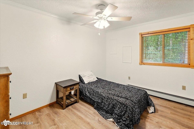 44775 Carver Dr, Kenai, AK 99611 - bedroom with light wood-type flooring, a textured ceiling, crown molding, a baseboard radiator, and baseboards