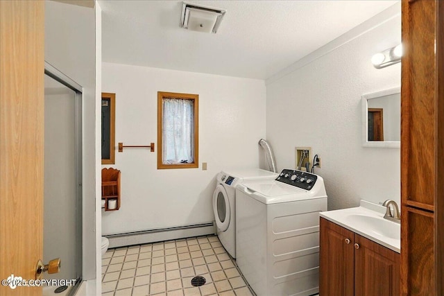 44775 Carver Dr, Kenai, AK 99611 - washroom with a baseboard heating unit, independent washer and dryer, light tile patterned floors, and cabinet space