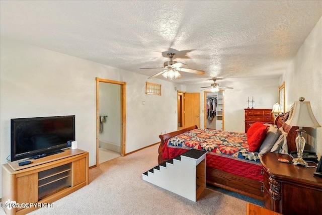 44775 Carver Dr, Kenai, AK 99611 - bedroom with carpet flooring, a textured ceiling, a walk in closet, ensuite bath, and a ceiling fan
