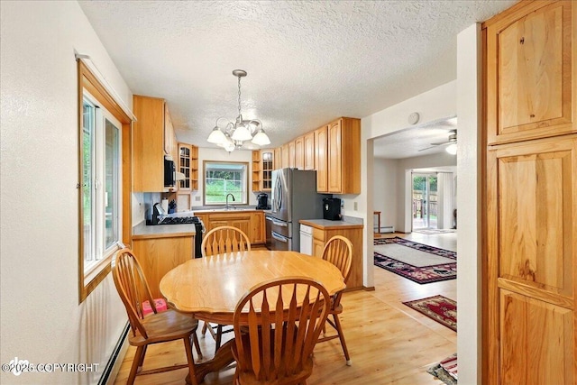 44775 Carver Dr, Kenai, AK 99611 - dining room with a textured ceiling, light wood-style floors, a chandelier, a ceiling fan, and a baseboard heating unit
