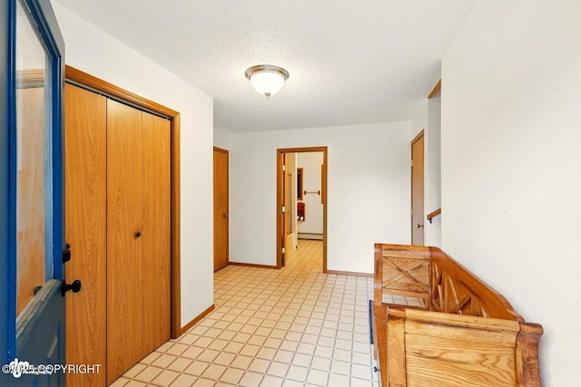 44775 Carver Dr, Kenai, AK 99611 - hall featuring a textured ceiling, baseboards, and light tile patterned floors