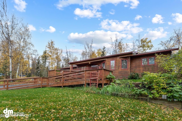 rear view of house with a deck and a lawn