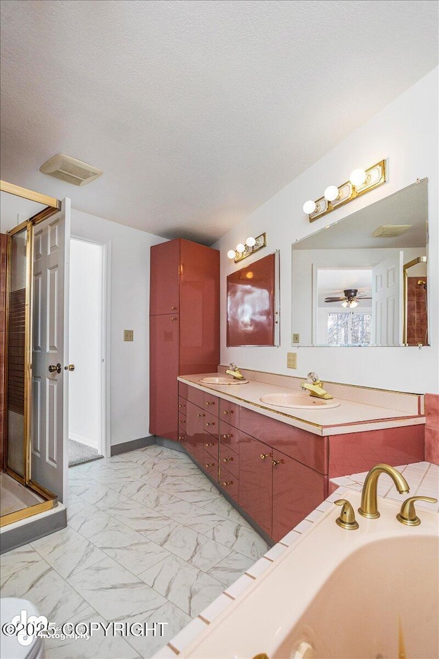 full bathroom featuring a textured ceiling, marble finish floor, double vanity, and a sink