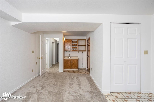 interior space featuring baseboards and light colored carpet