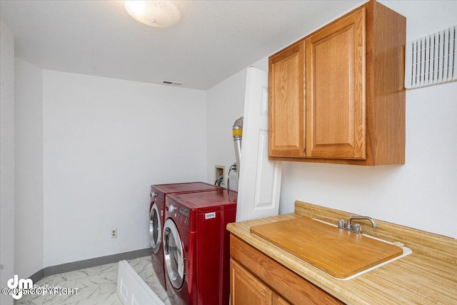 clothes washing area featuring a sink, visible vents, baseboards, marble finish floor, and independent washer and dryer