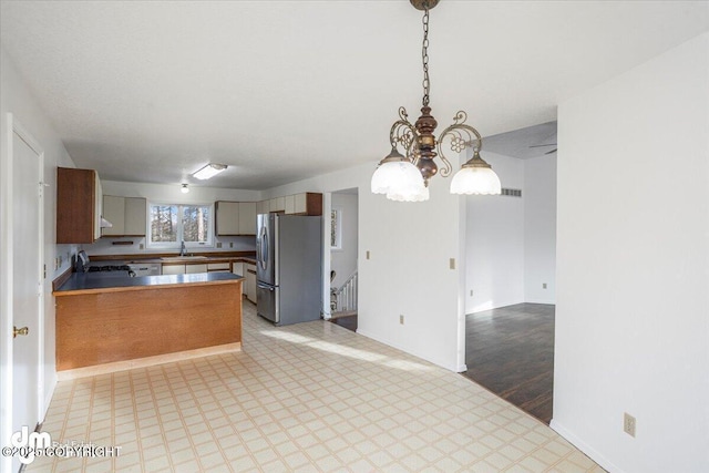 kitchen featuring stainless steel appliances, a peninsula, visible vents, open floor plan, and pendant lighting