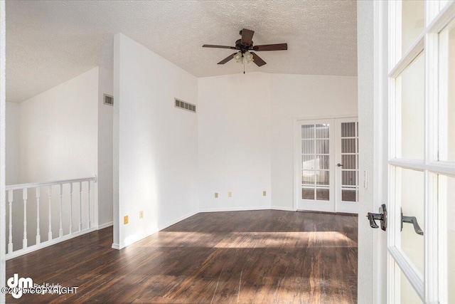 empty room featuring dark wood-style floors, french doors, visible vents, and vaulted ceiling